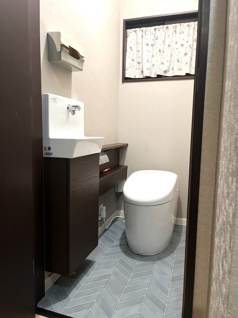 施工後の様子です。トイレの給水を利用して、床や壁を壊すことなく手洗いを取り付けました。
また、同時に床、壁紙も貼替をし、高級感のある落ち着いたトイレになりました。